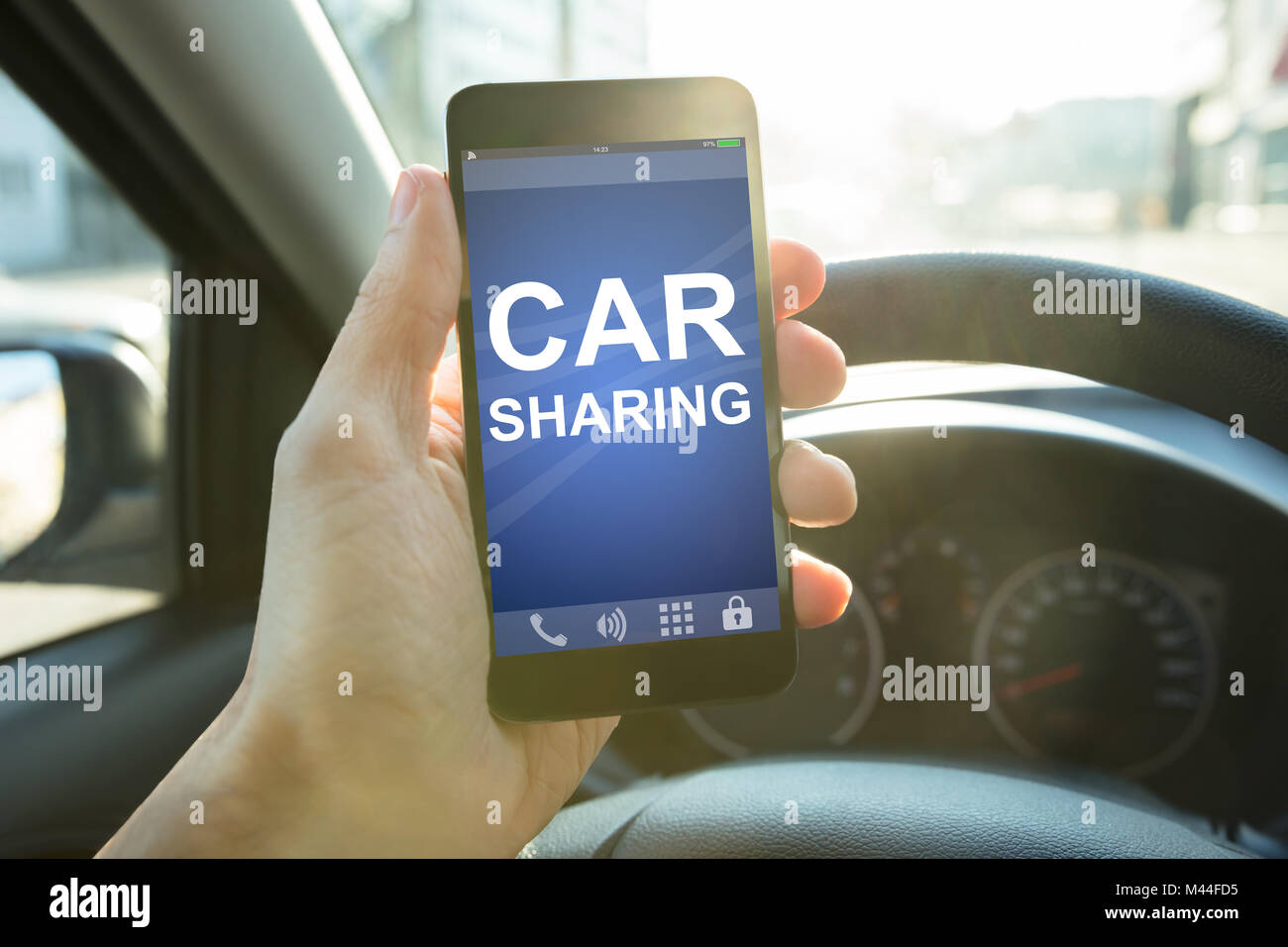 Nahaufnahme der Hand Mann, smart phone mit Car sharing App auf dem Bildschirm im Auto. Stockfoto