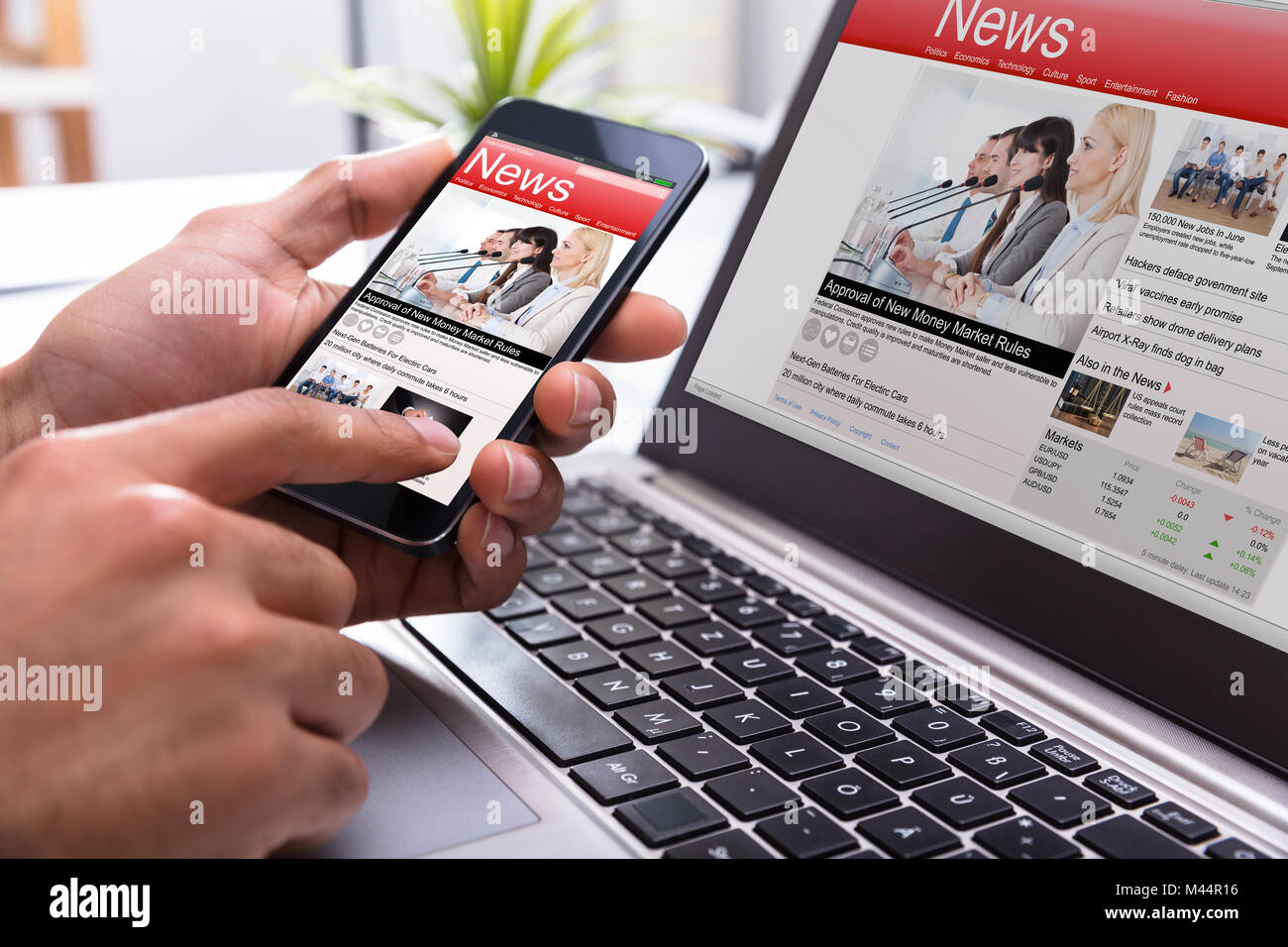 Nahaufnahme der Kaufmann Hand Smartphone mit on-line-Nachrichten auf dem Bildschirm am Arbeitsplatz Stockfoto