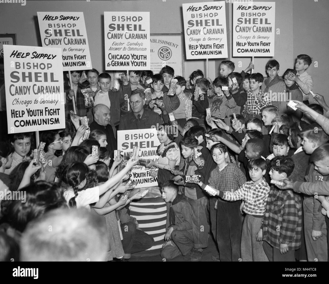 Bischof Bernard Sheil, Gründer der Katholischen Jugend Organisation (cyo) mit einer Gruppe von Chicago Jugend Anzeige Süßigkeit zu den Deutschen Jugend gesendet werden, Ca. 1950. Stockfoto