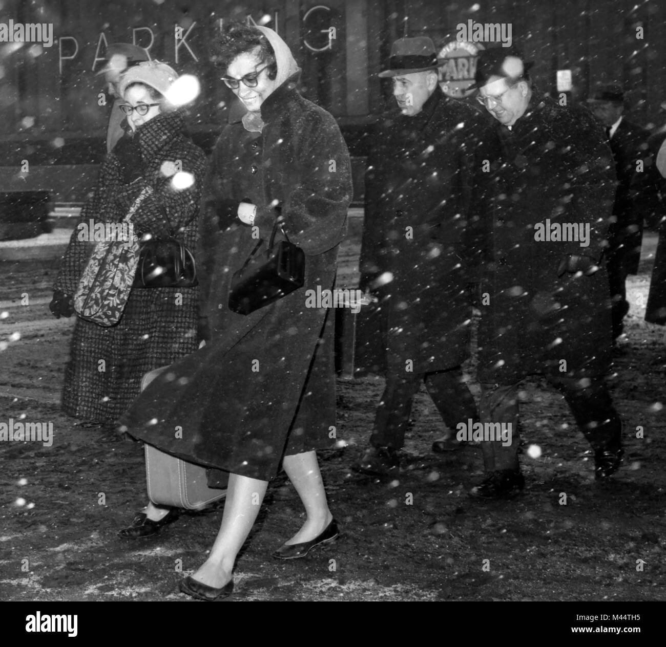 Fußgänger zu Fuß eine Straße in der Innenstadt von Chicago bei einem Schneesturm, Ca. 1960 Stockfoto