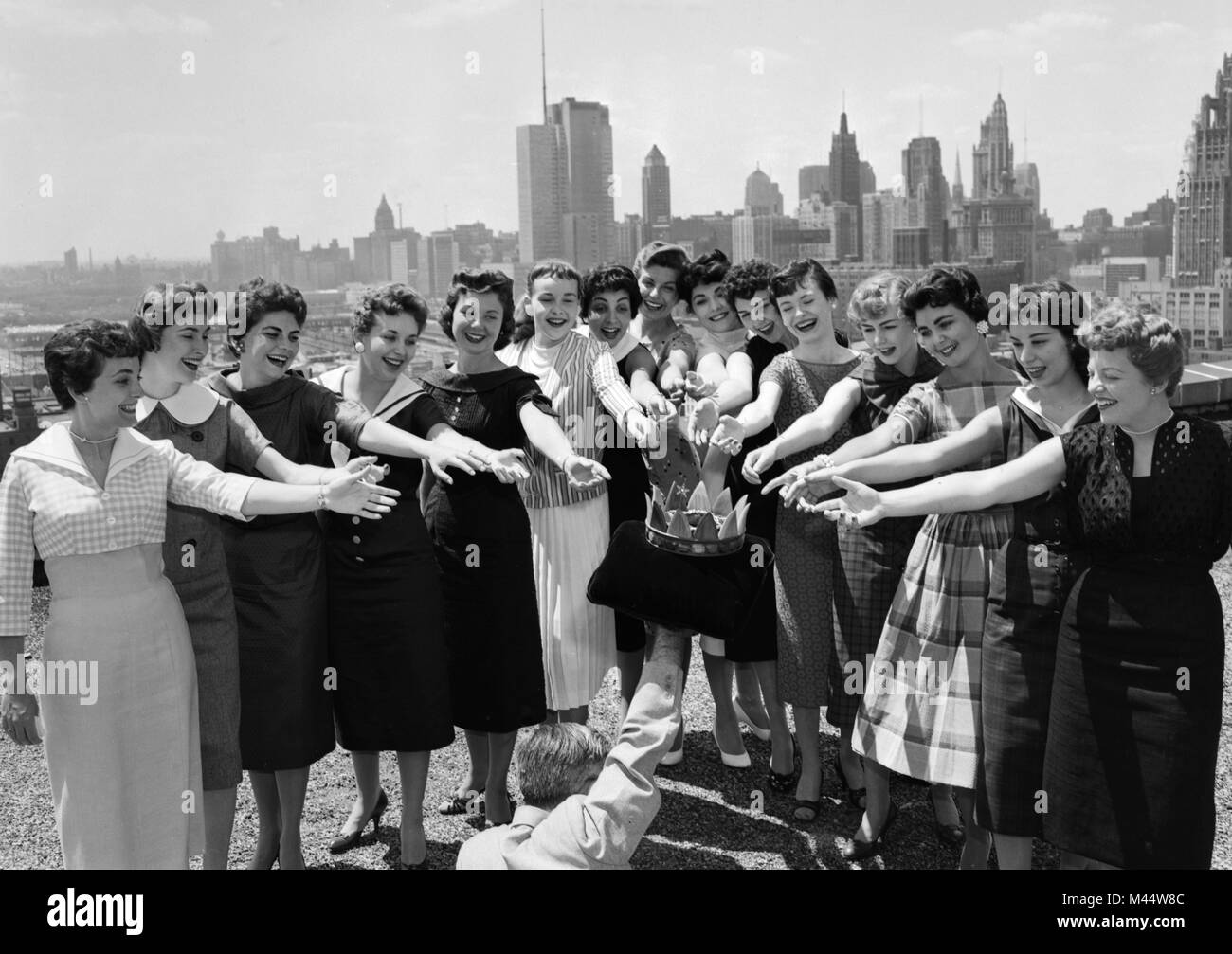 Schönheit Pageant Kandidaten erreichen für eine Krone von der Assistent eines Fotografen gehalten, Ca. 1959. Stockfoto