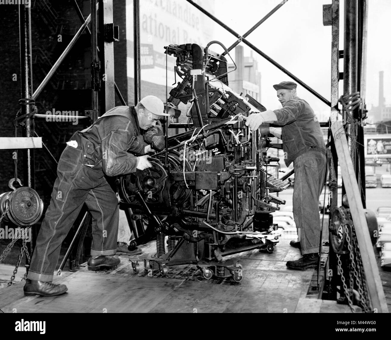 Drei Arbeitnehmer, die Teil einer Druckmaschine auf einer geladenen Dock in den späten 1958. Stockfoto