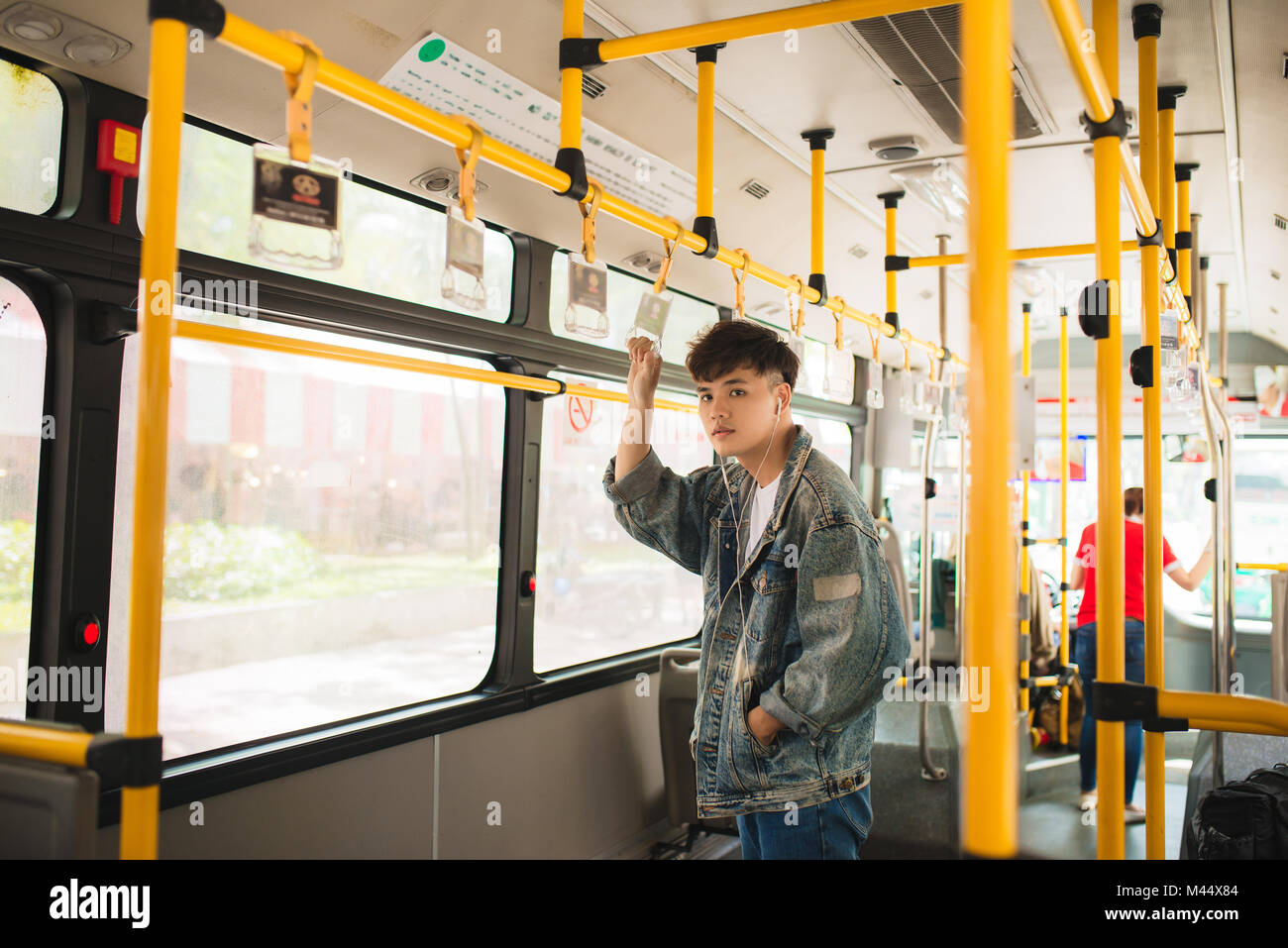 Asiatischer Mann mit den öffentlichen Verkehrsmitteln, Bus stehen. Stockfoto