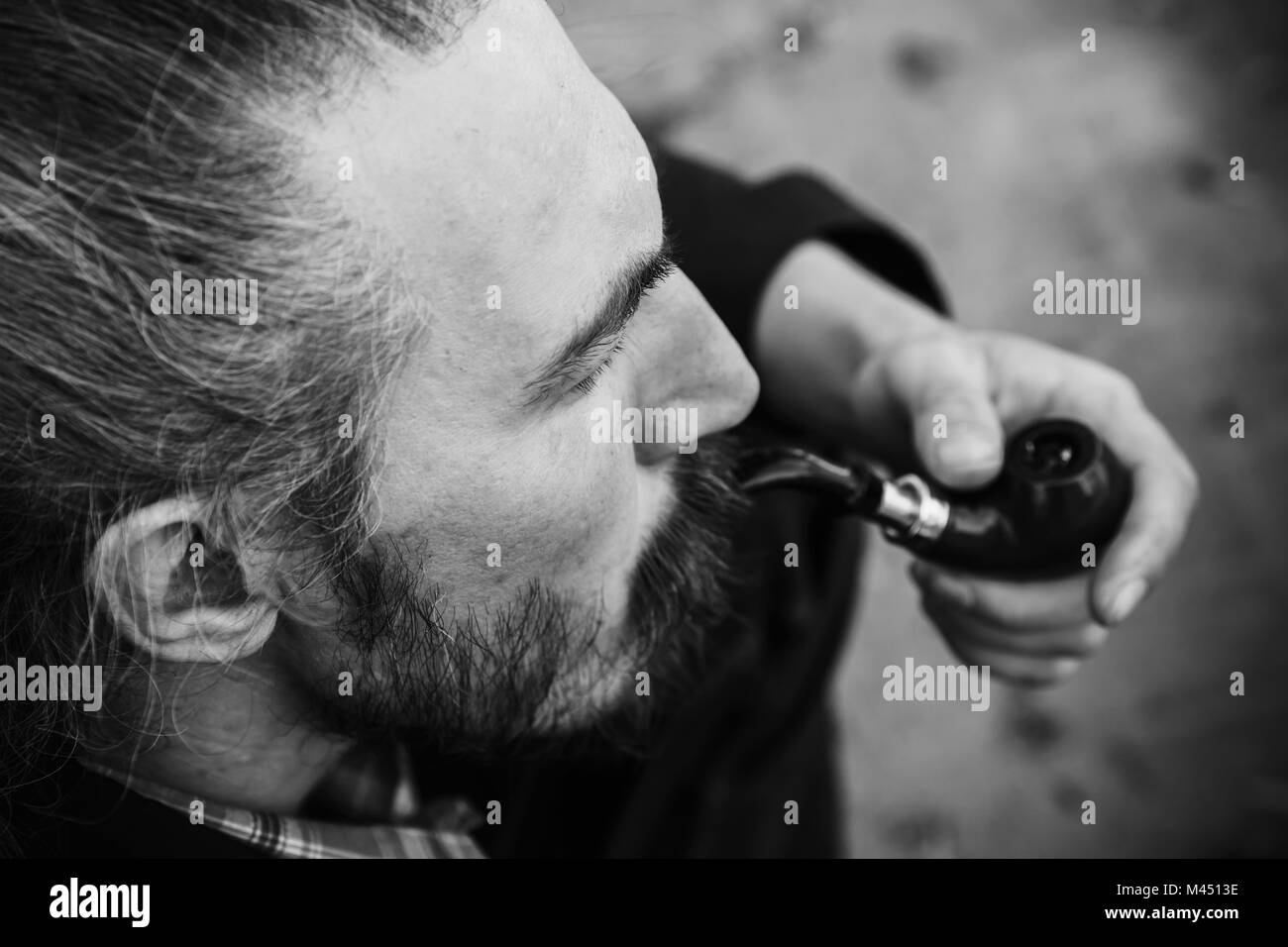 Bärtiger Mann raucht eine Pfeife, schwarzen und weißen Gesicht Porträt mit selektiven Fokus Stockfoto