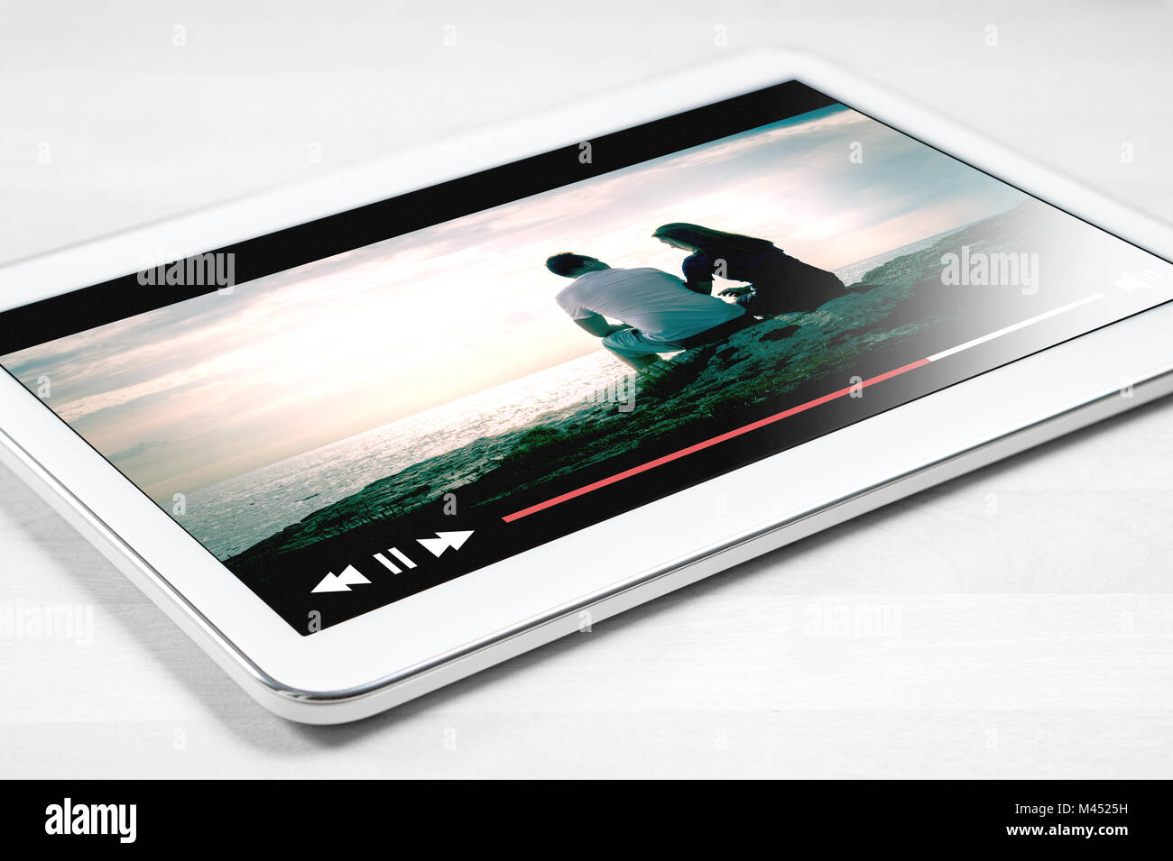 Online Film streamen mit mobilen Gerät. Weiße Tablette auf Holztisch mit imaginären Video Player und Streaming Film Service. Stockfoto