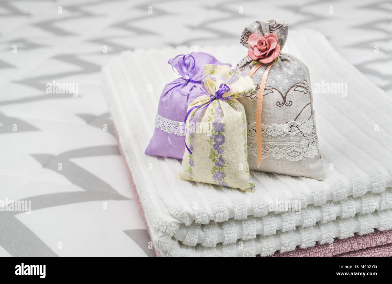 Drei Lavendel Duft Beutel auf Handtücher. Kleine Säckchen auf Schlafzimmer Bett. Duft Beutel für Frische. Dekoration, Ausstattung und Zubehör. Stockfoto