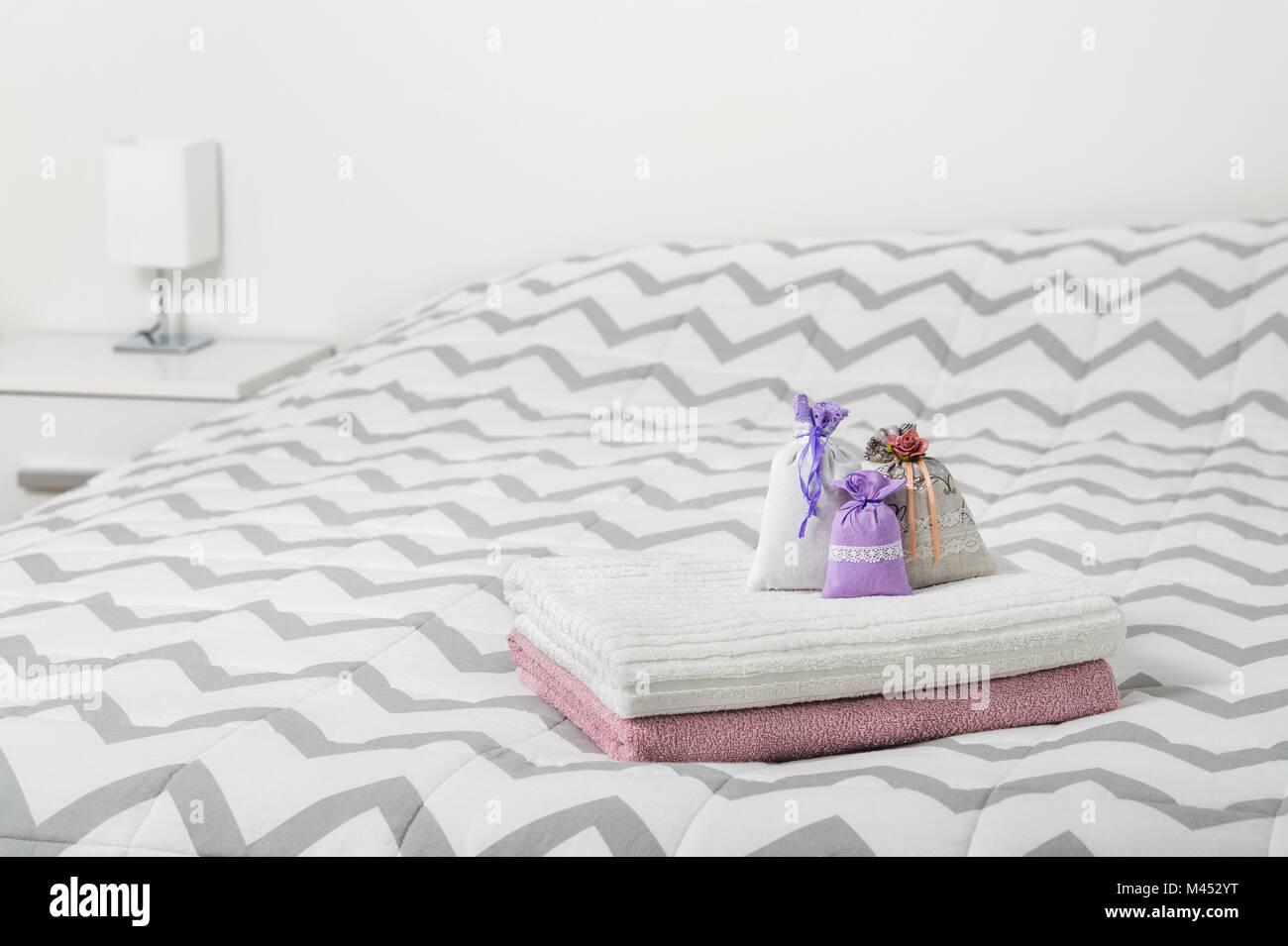 Dekoration Zubehör und hellen skandinavischen Design. Kleine Säckchen und Lavendel Beutel auf Handtücher auf dem Bett. Beutel gefüllt mit Lavendel. Stockfoto