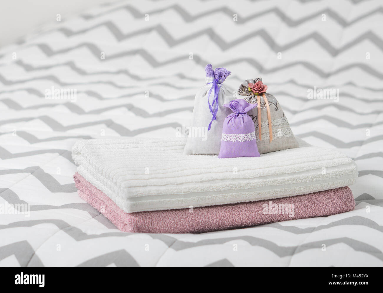 Aromatische Potpourri auf Bett gesetzt. Drei Lavendel Duft Beutel auf Handtücher. Kleine Säckchen mit im Schlafzimmer. Duft Beutel für Frische. Dekoration. Stockfoto