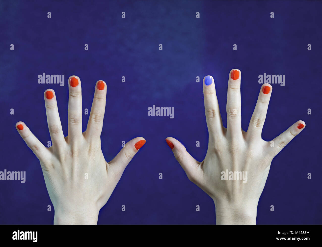 Man verschiedene Nagellack in Finger in weißen Händen. Rot und Blau lackierte Fingernägel. Heben Sie sich von der Masse ab, Originalität und Kreativität. Stockfoto