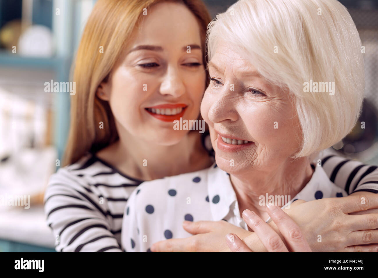 In der Nähe der charmanten Tochter ihrer älteren Mutter umarmt Stockfoto