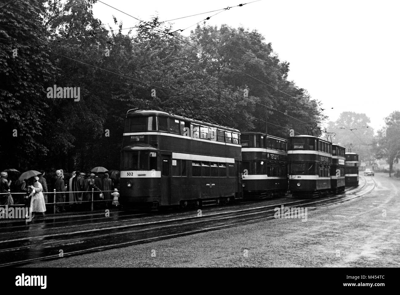 Leeds Corporation Straßenbahnen 502 (Feltham Auto), 201 und andere auf einem nassen und regnerischen Tag. Bild in der 1950 s Stockfoto