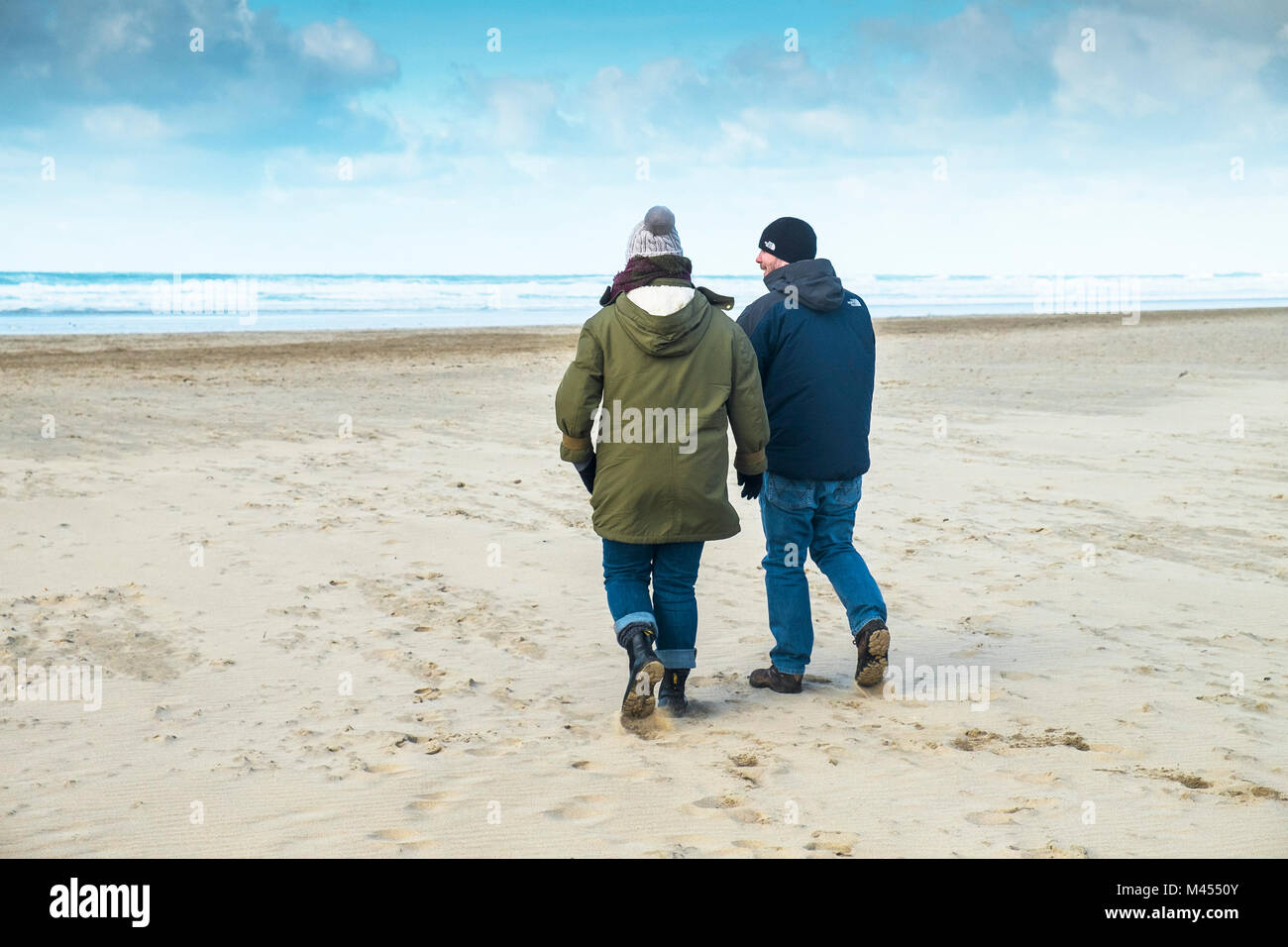 Zwei Menschen gehüllt vor dem kalten Wetter zu Fuß am Strand. Stockfoto