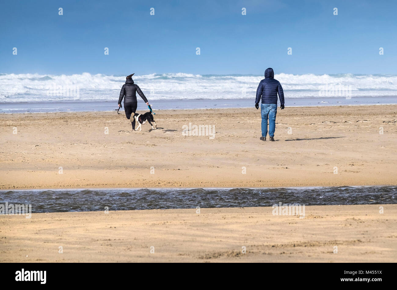 Leute, die ihren Hund am Strand in Perranporth Cornwall. Stockfoto