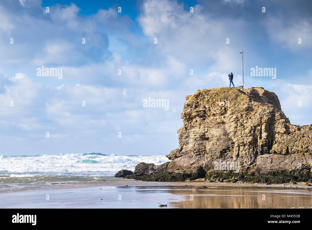 Ein Mann stand an der Spitze der Kapelle Rock Perranporth Strand in Cornwall, England. Stockfoto