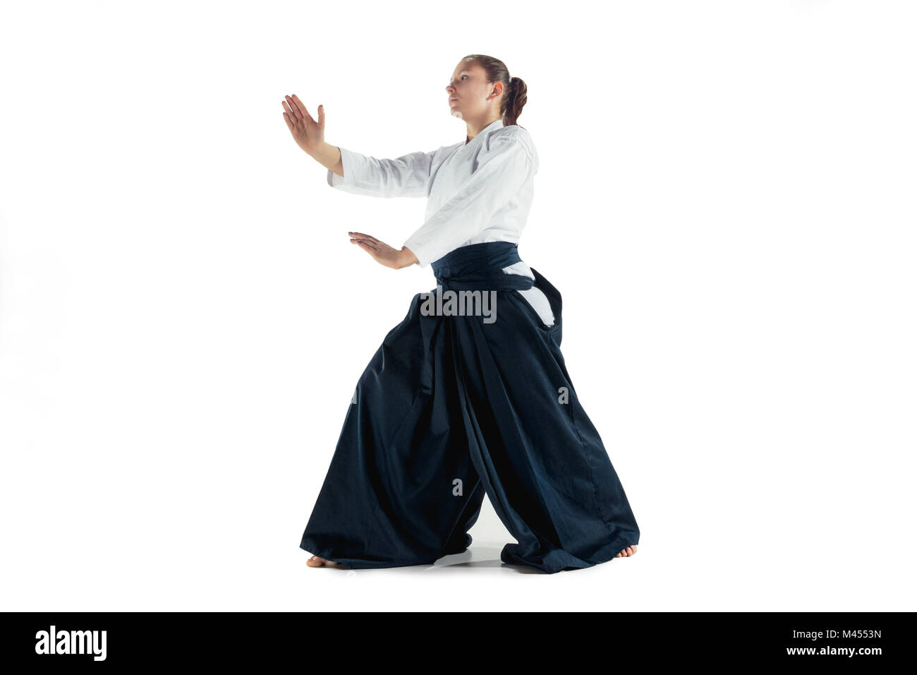Aikido master Praktiken verteidigungsdispositiv. Gesunder Lebensstil und Sport Konzept. Frau in weißem Kimono auf weißem Hintergrund. Stockfoto
