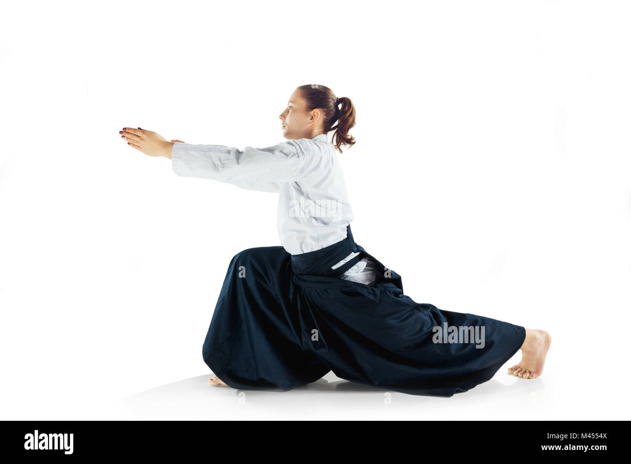 Aikido master Praktiken verteidigungsdispositiv. Gesunder Lebensstil und Sport Konzept. Frau in weißem Kimono auf weißem Hintergrund. Stockfoto