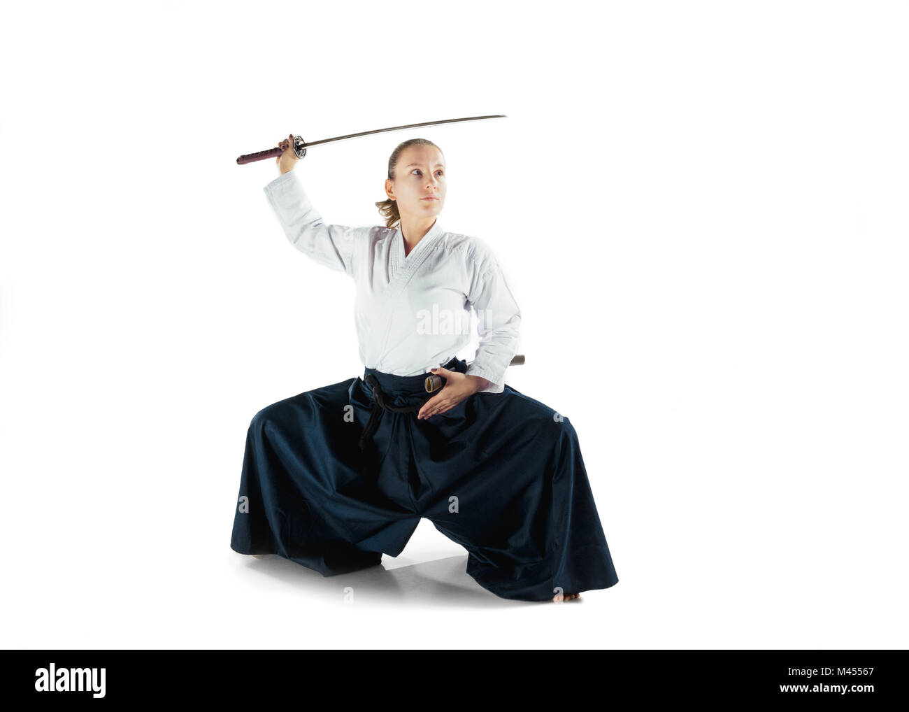 Aikido master Praktiken verteidigungsdispositiv. Gesunder Lebensstil und Sport Konzept. Frau in weißem Kimono auf weißem Hintergrund. Stockfoto