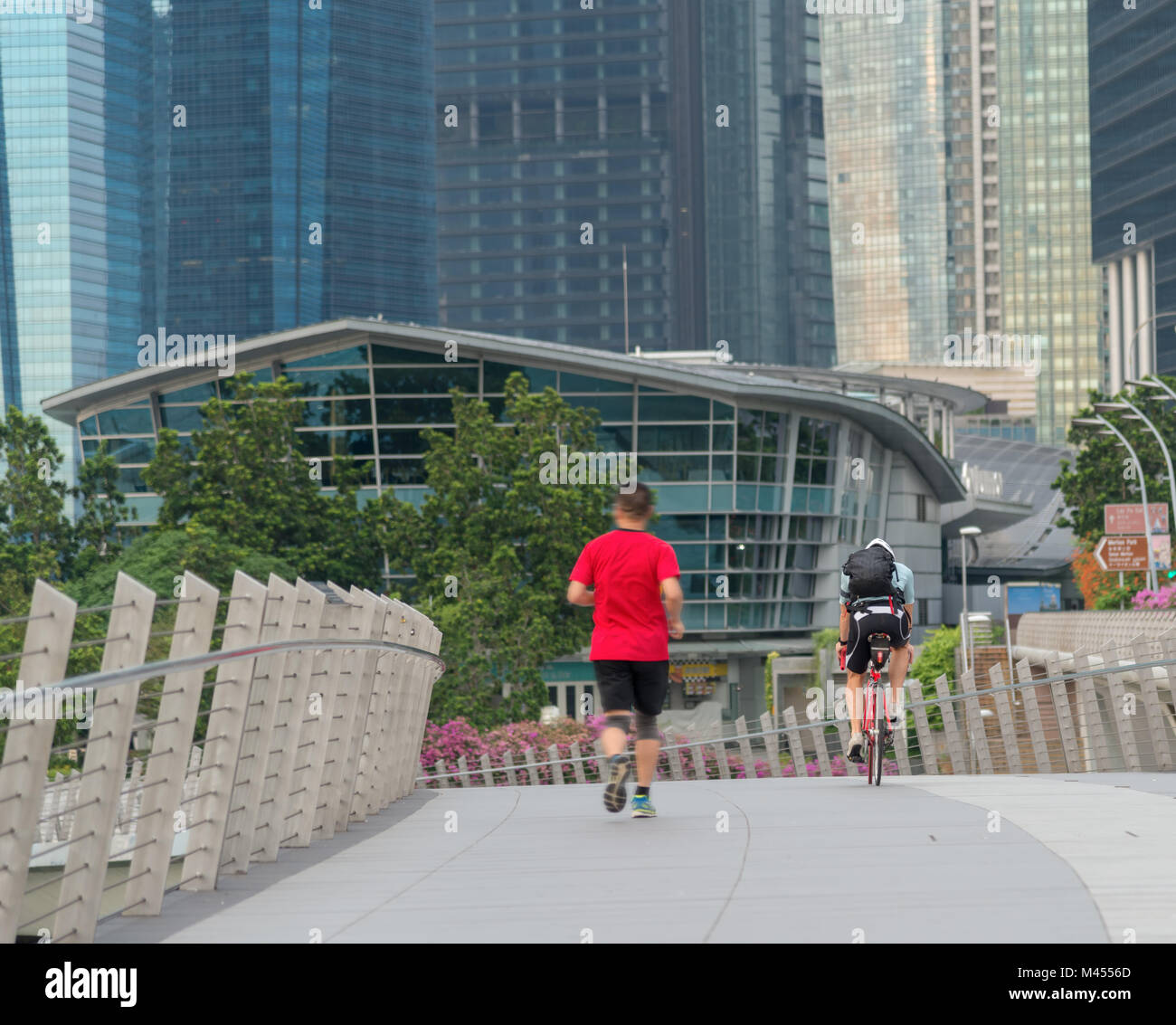 Läufer und Radfahrer Übung morgens entlang der Brücke in der Nähe der Marina Bay in Singapur Stockfoto