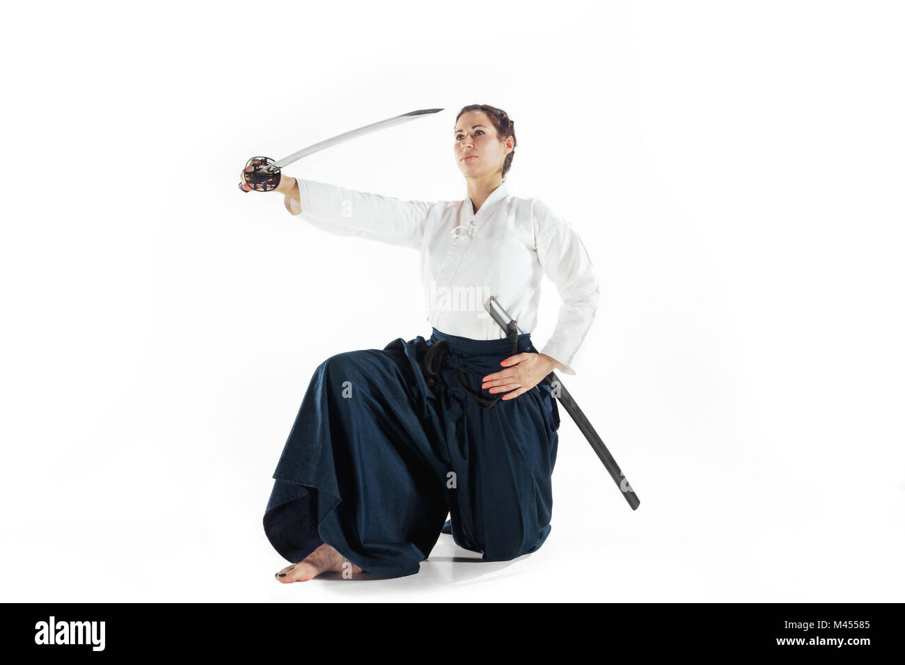 Aikido master Praktiken verteidigungsdispositiv. Gesunder Lebensstil und Sport Konzept. Frau in weißem Kimono auf weißem Hintergrund. Stockfoto