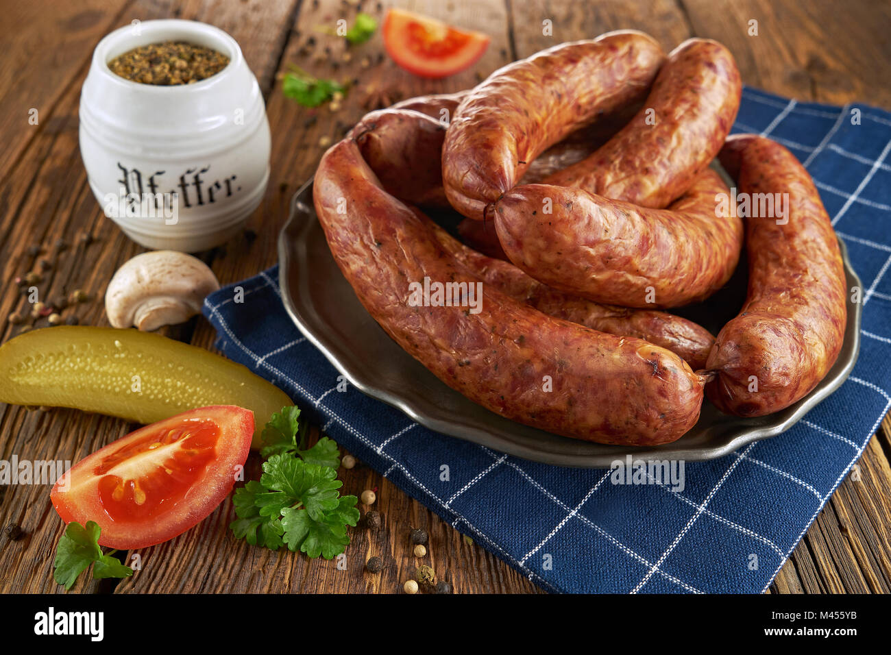 Traditionelle polnische Würstchen auf einem Metallauflagefach, auf alten Brettern Stockfoto