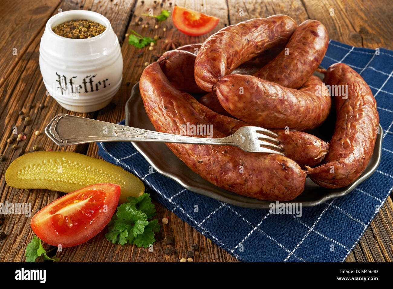 Traditionelle polnische Würstchen auf einem Metallauflagefach, auf alten Brettern Stockfoto