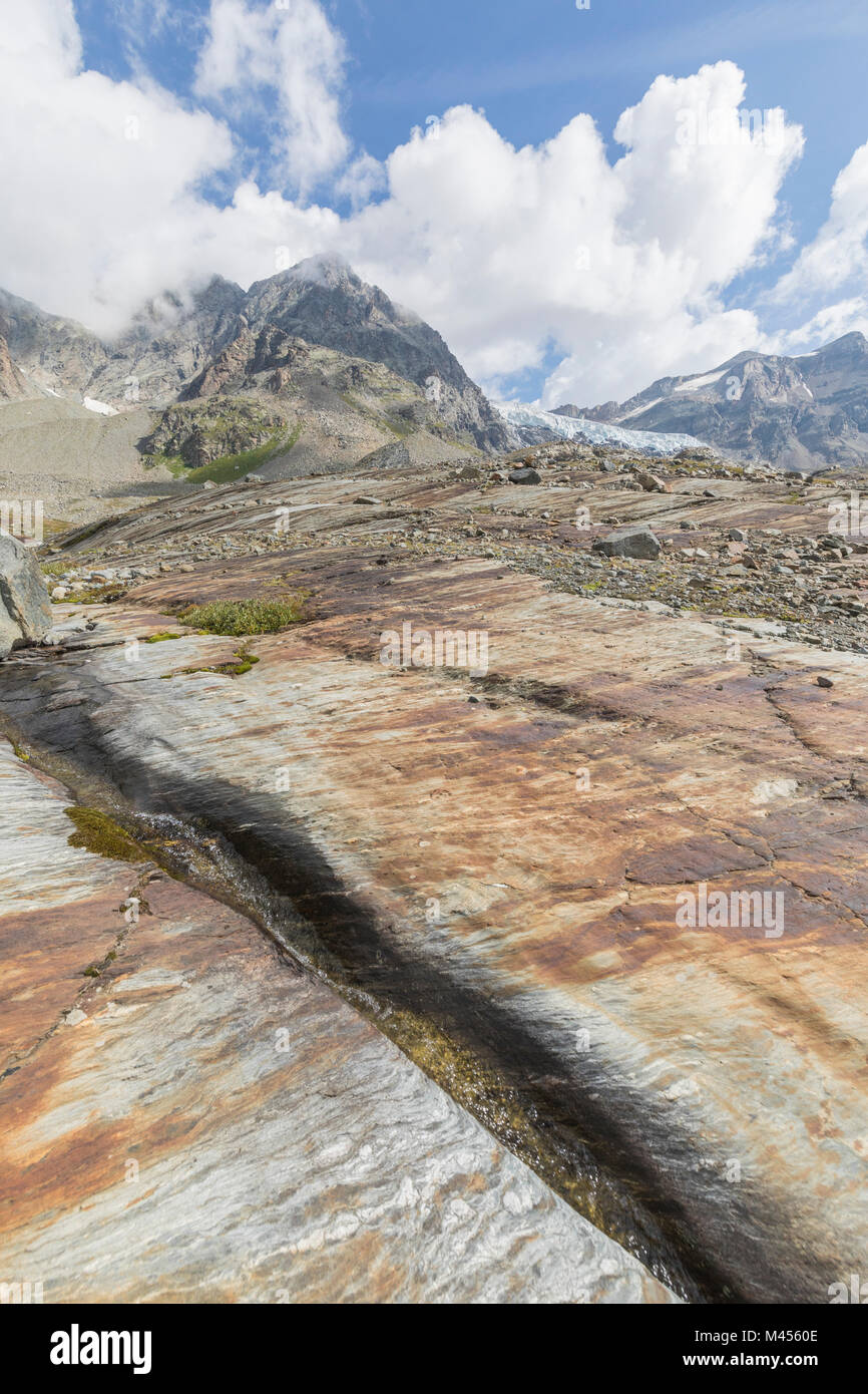 Steinplatten mit Fellaria Gletscher im Hintergrund, Sentiero Malenco Glaciologico, Valley, Valtellina, Lombardei, Italien Stockfoto
