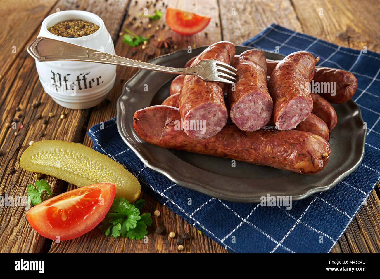 Traditionelle polnische Würstchen auf einem Metallauflagefach, auf alten Brettern Stockfoto