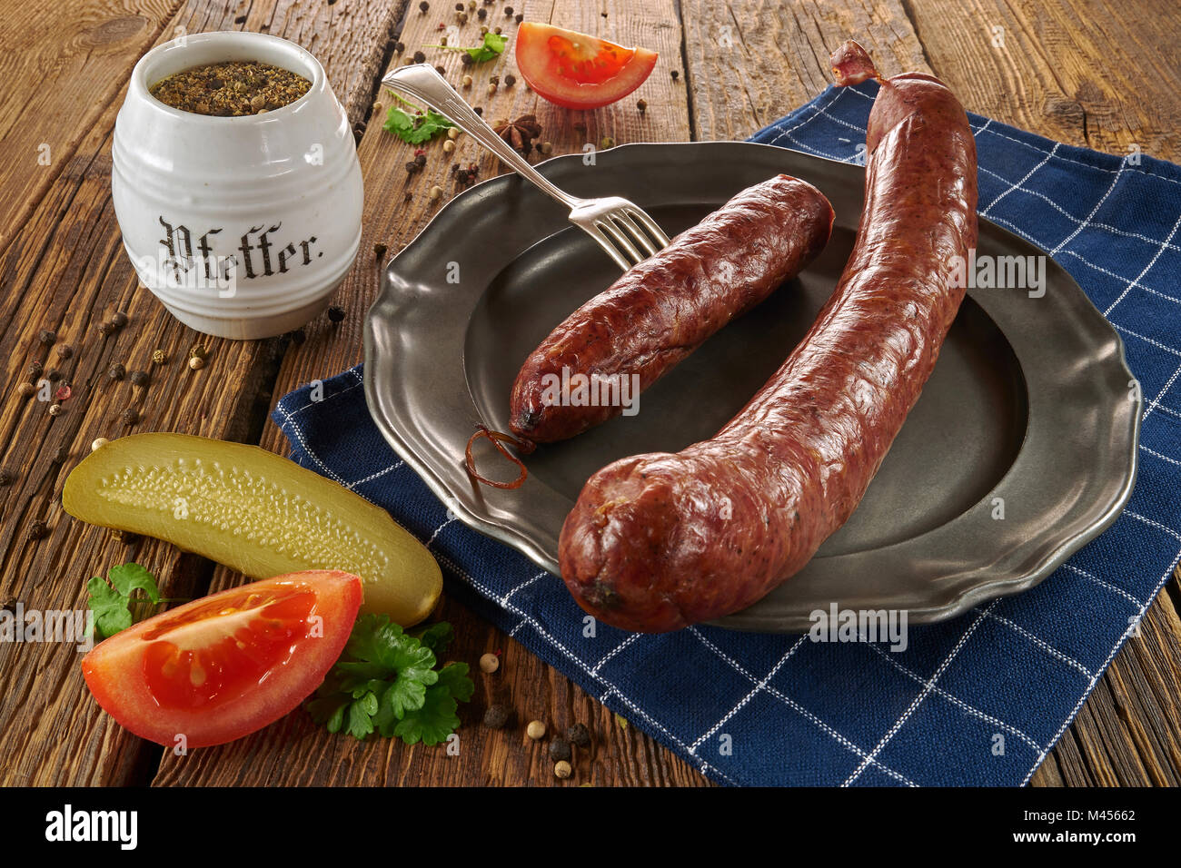Traditionelle polnische Würstchen auf einem Metallauflagefach, auf alten Brettern Stockfoto
