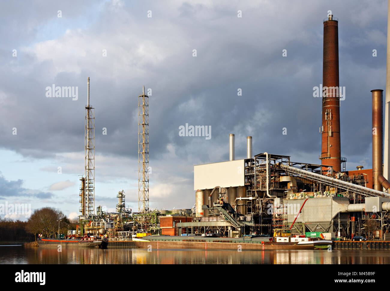 Eine alte Ölraffinerie mit angedockten Schiffe an einem Kanal. Stockfoto