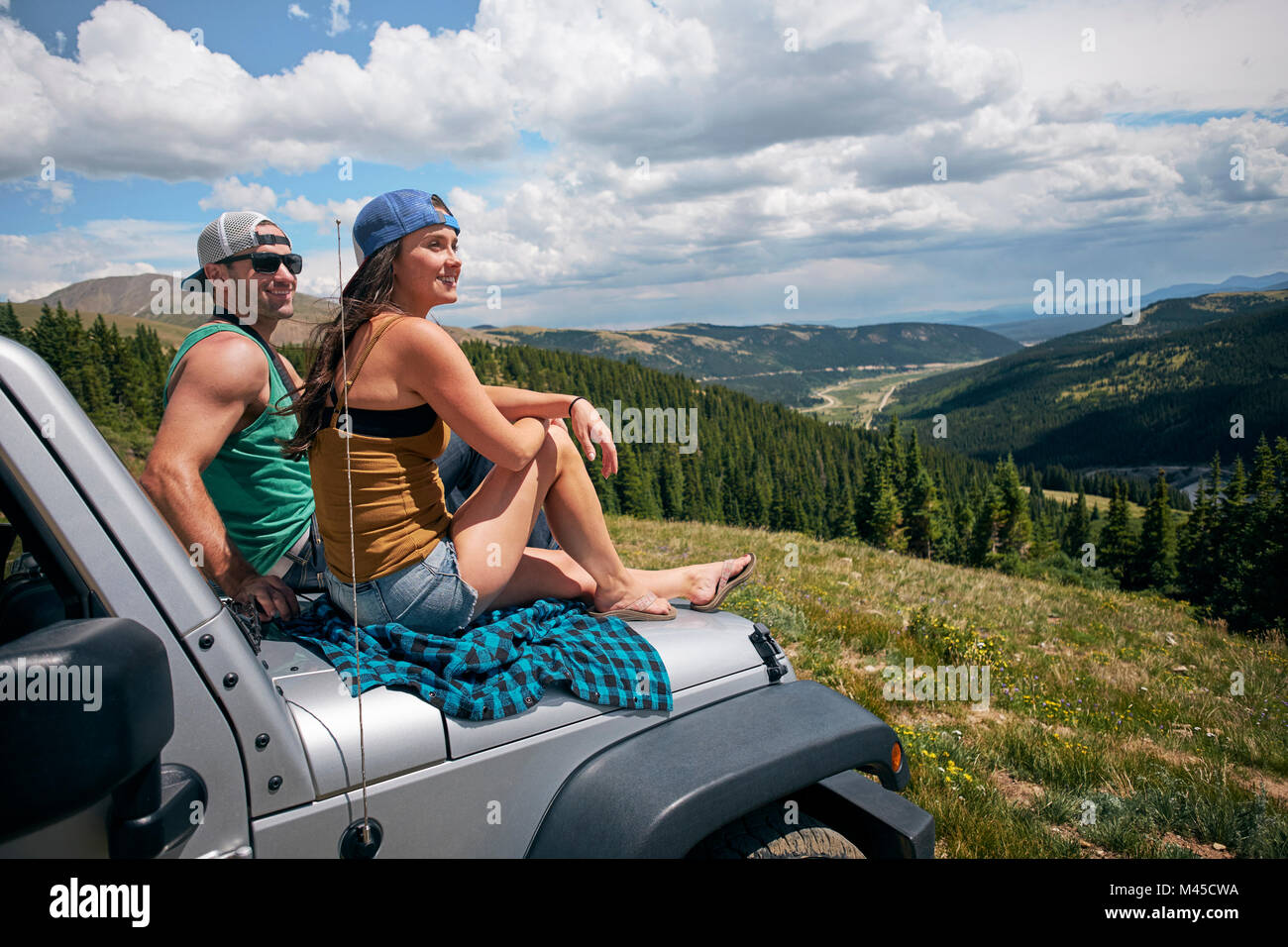 Road Trip Paar aus dem Auto Motorhaube in Rocky Mountains, Breckenridge, Colorado, USA suchen Stockfoto