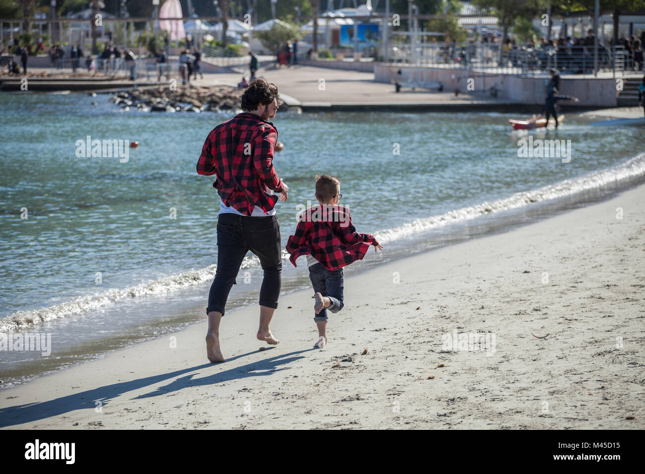 Vater und Sohn Strand entlang läuft, Ansicht von hinten Stockfoto