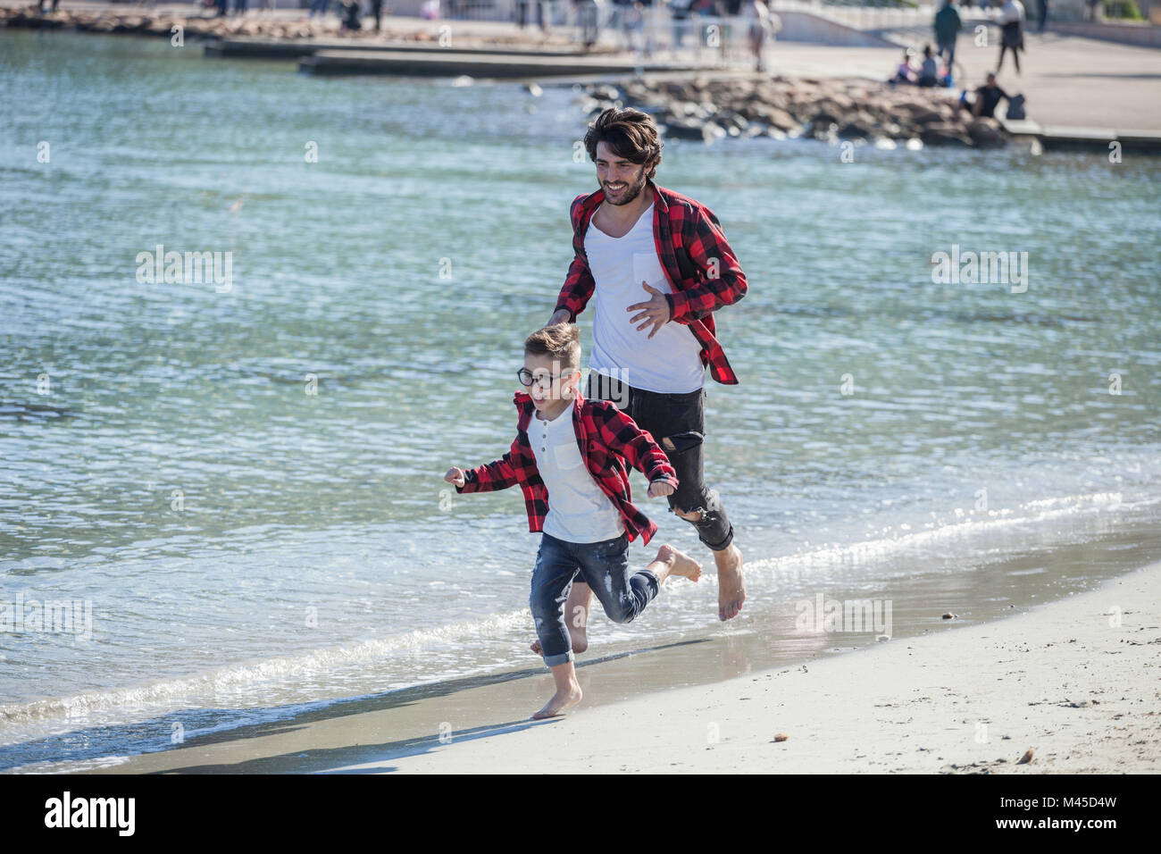Vater und Sohn Strand entlang läuft Stockfoto