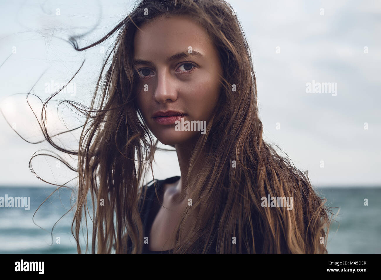 Porträt der jungen Frau mit Flyaway lange Haare am Strand, Odessa, Odessa, Ukraine Stockfoto