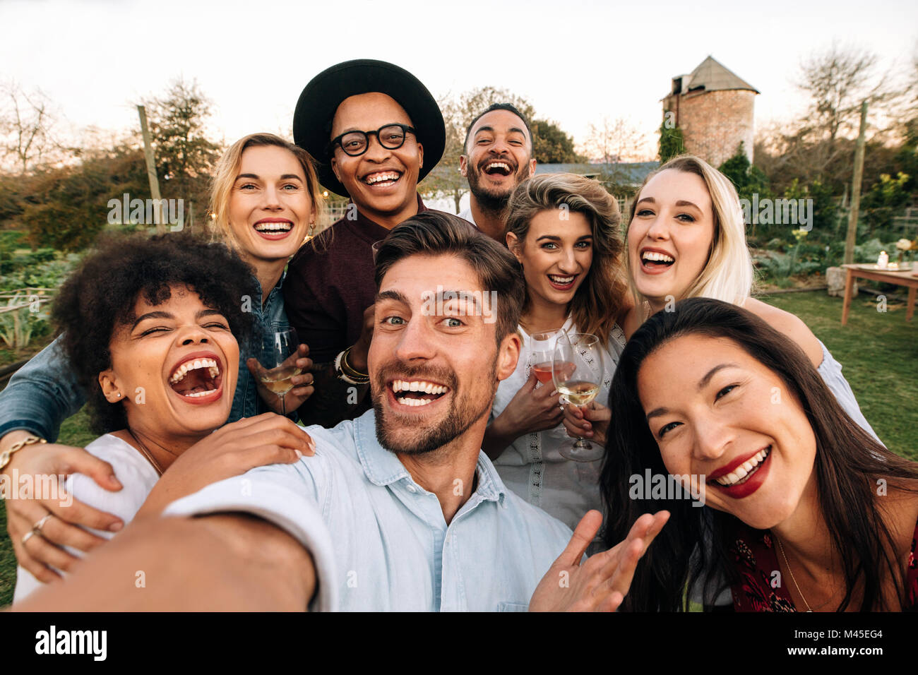 Freunde außerhalb der Gruppe selfie und lächelnd Chillen. Lachende junge Menschen gemeinsam im Freien und unter selfie. Stockfoto