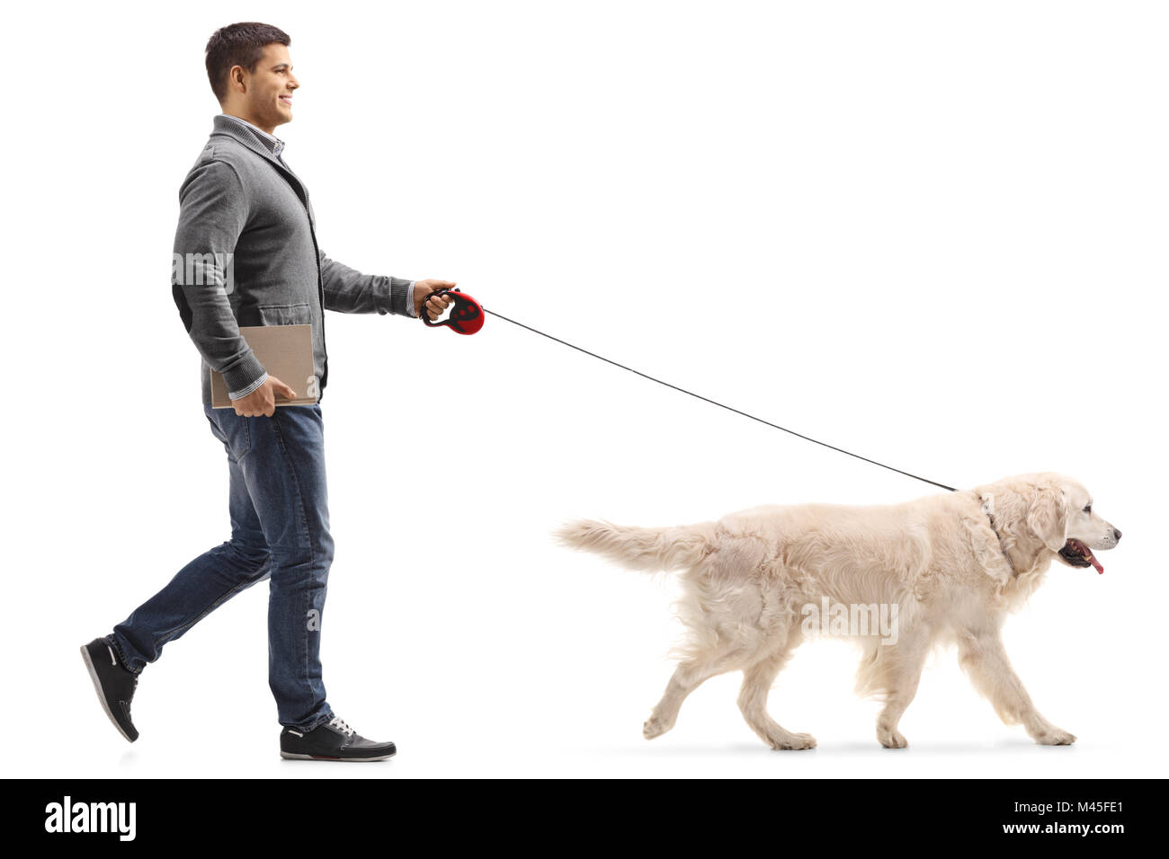 Volle Länge Profil geschossen von einem Mann mit einem Buch zu Fuß einen Hund auf weißem Hintergrund Stockfoto