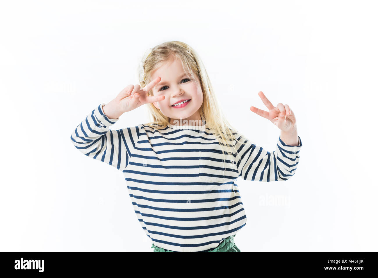 Lächelnd Kind tanzen und Frieden Gesten mit Händen isoliert auf weißem Stockfoto