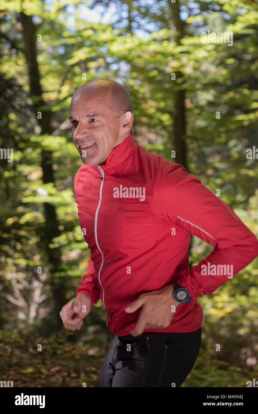 Reife männliche Läufer in Woodland läuft Stockfoto