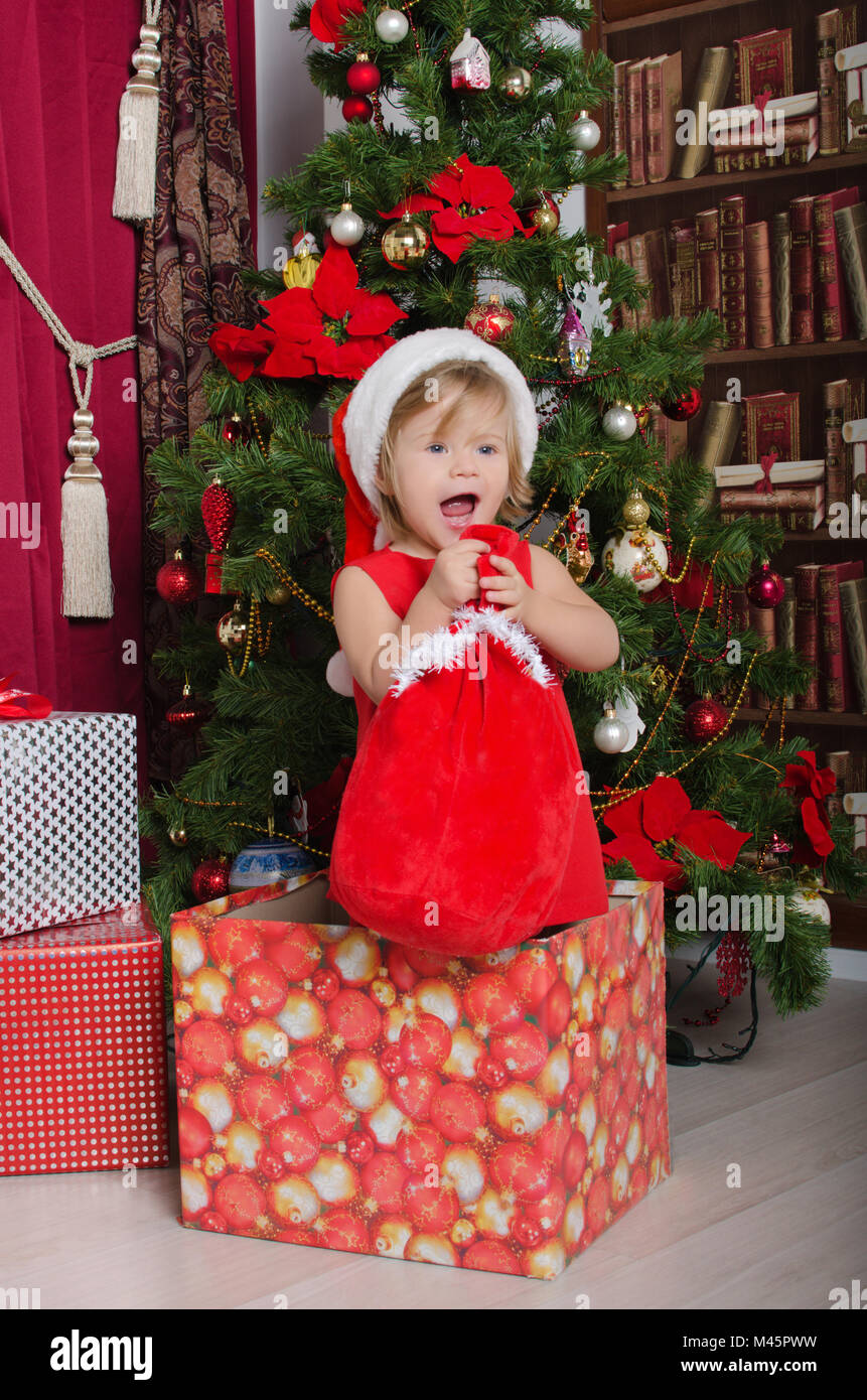 Kind verkleidet als Weihnachtsmann in Box mit Geschenk Tasche Stockfoto
