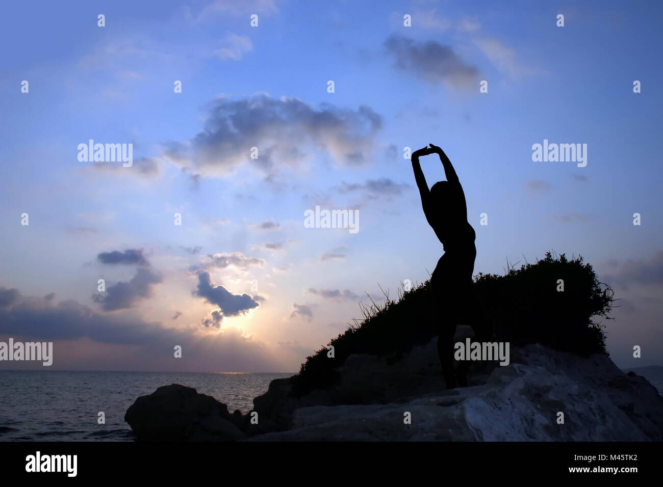 Silhouette eines Mädchens gegen Sonnenuntergang Stockfoto