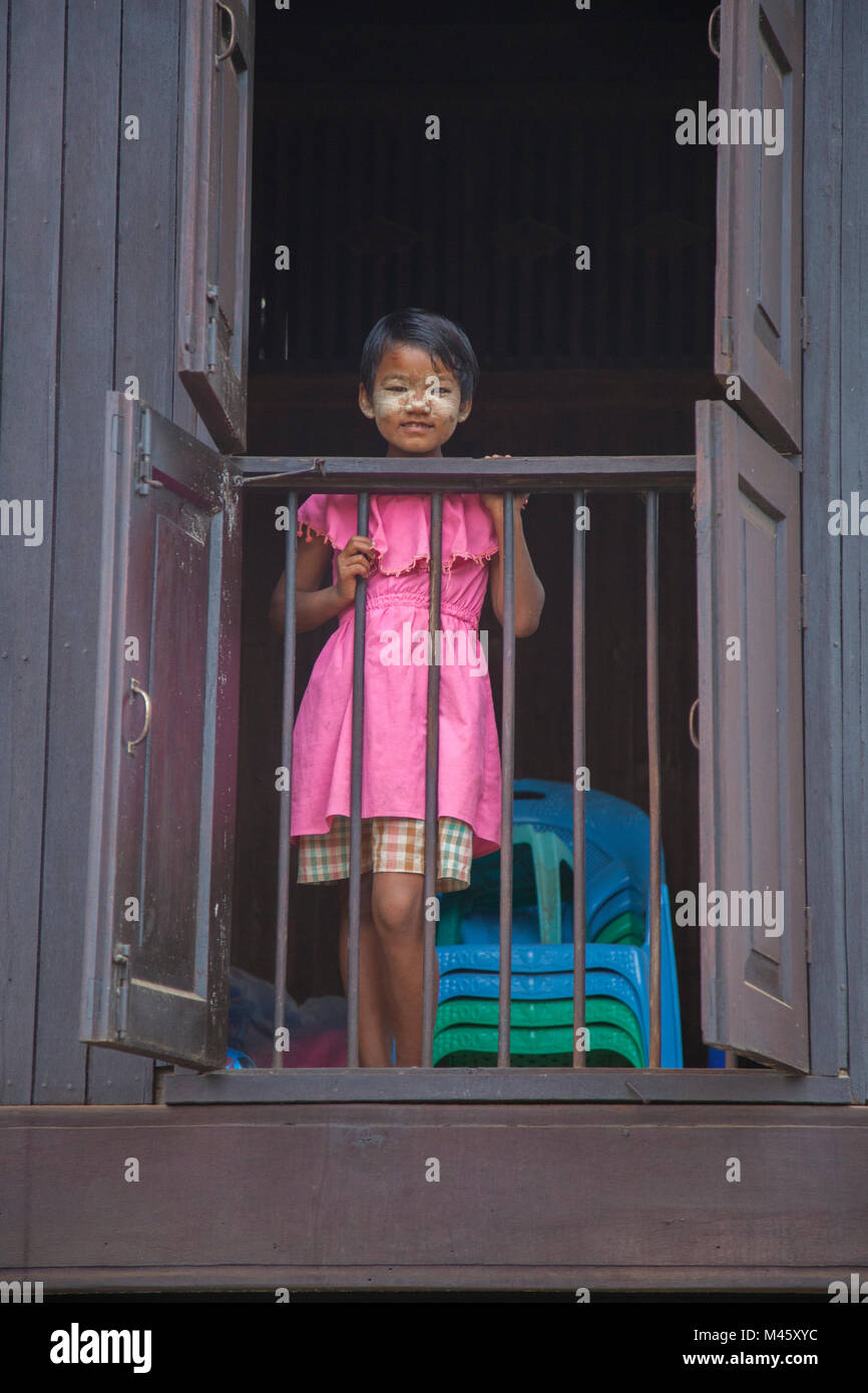 Die jungen Burmesischen stehendes Mädchen an ihrem Haus windown in Bagan Myanmar Stockfoto