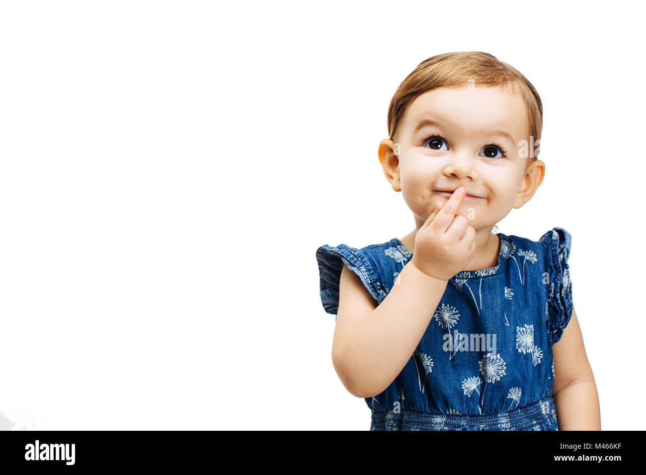 Glücklich und neugierig Kleinkind Mädchen denken mit einem Finger durch den Mund Stockfoto
