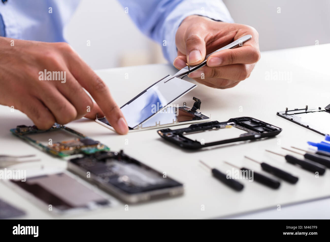 In der Nähe von einem Techniker Hand Reparieren beschädigter Bildschirm auf dem Mobiltelefon Stockfoto