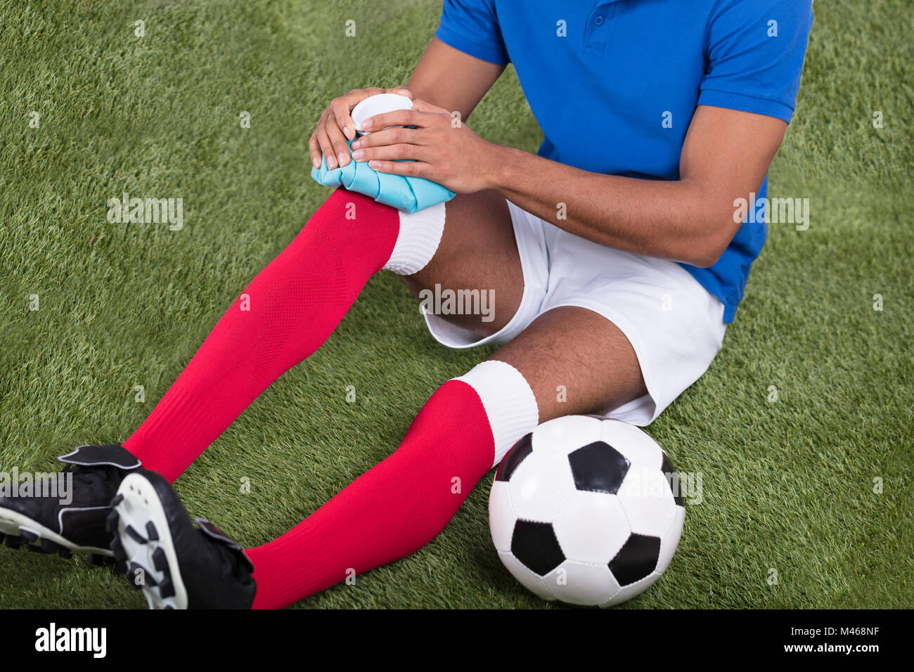 Nahaufnahme eines Verletzten männlichen Fußball-Spieler Anwendung Ice Pack auf Knie Stockfoto