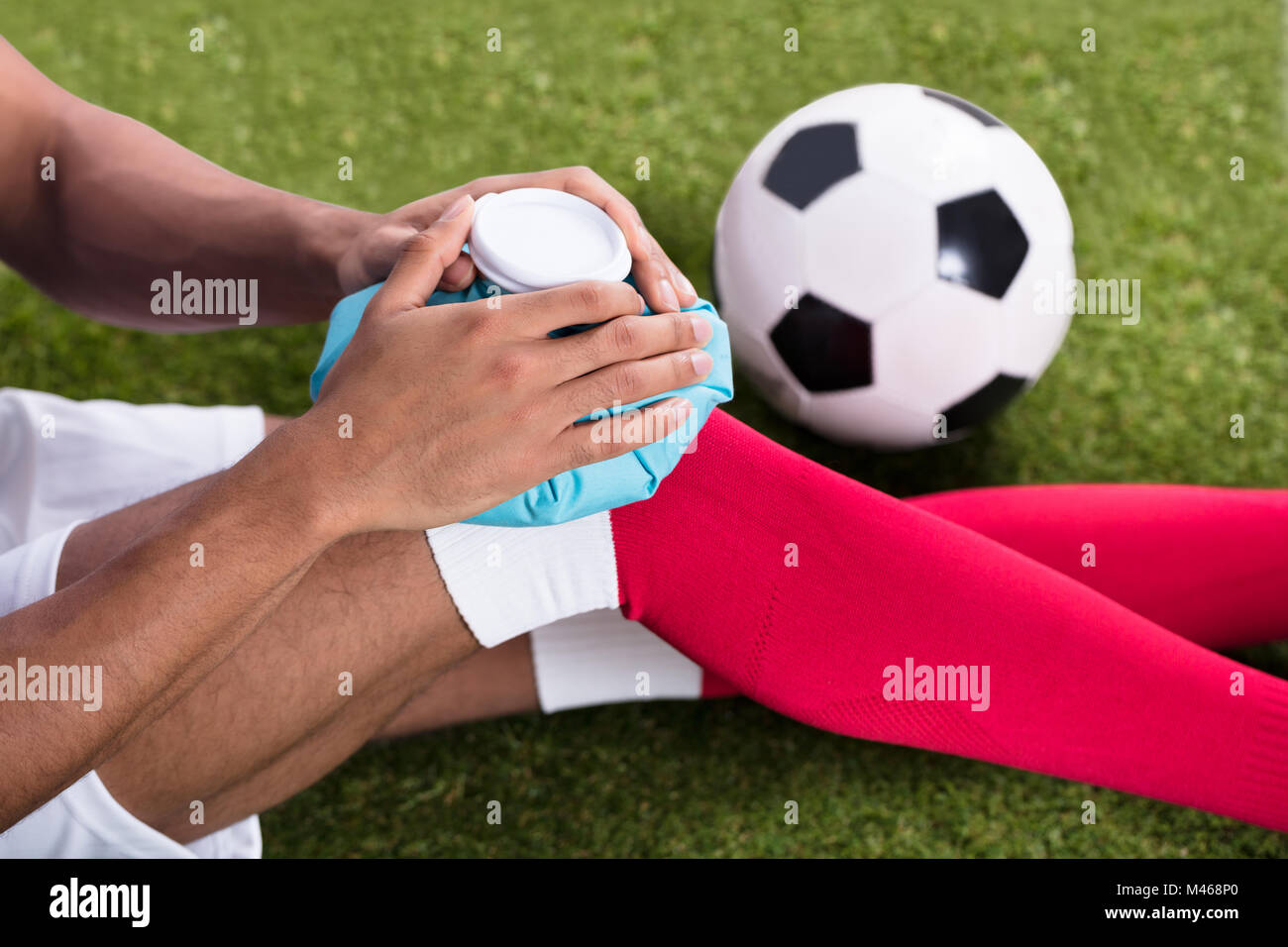 Nahaufnahme eines Verletzten männlichen Fußball-Spieler Anwendung Ice Pack auf Knie Stockfoto
