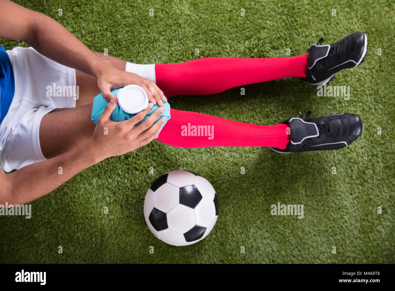 Nahaufnahme eines Verletzten männlichen Fußball-Spieler Anwendung Ice Pack auf Knie Stockfoto