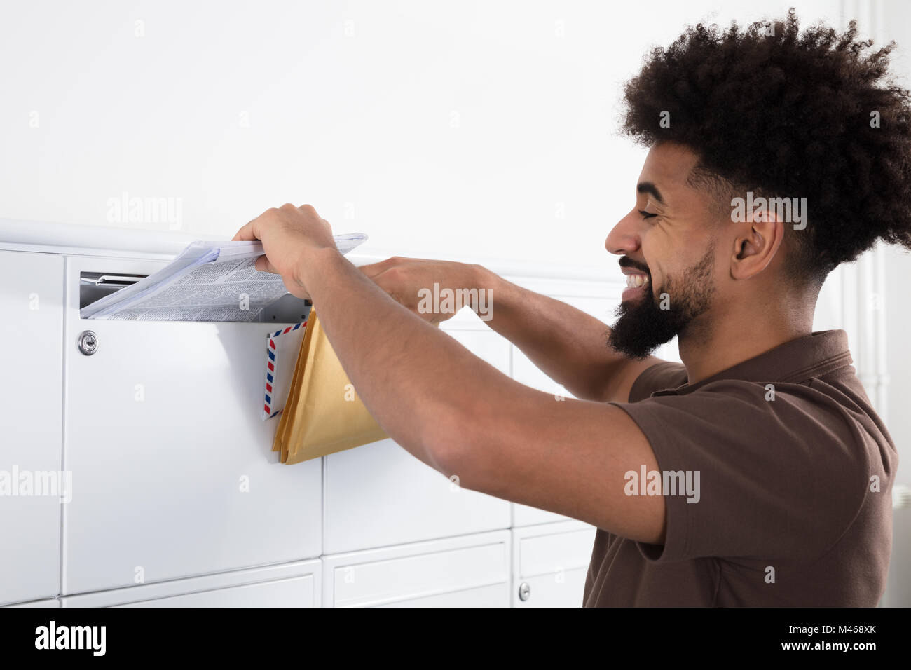 Seitenansicht eines jungen Mannes, Briefe in der Mailbox Stockfoto