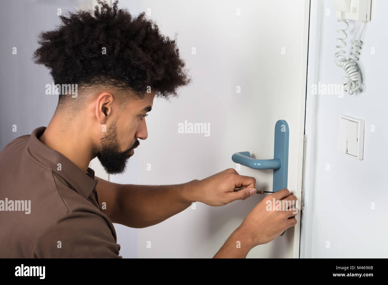 Nahaufnahme von einer Person Hand zu öffnende Tür mit Lockpicker Stockfoto