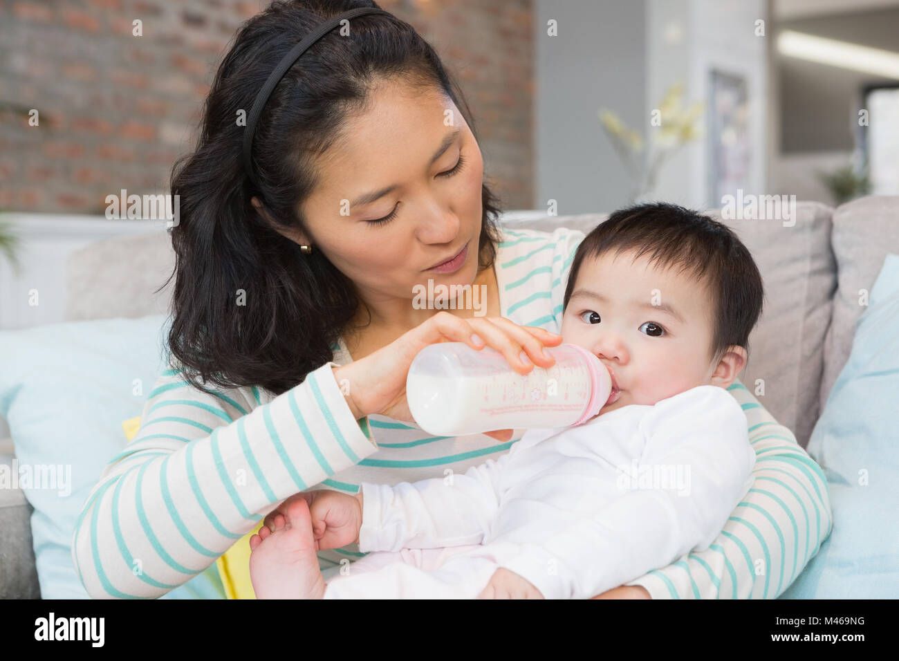 Mutter Tochter Milch in der Flasche geben Stockfotografie Alamy