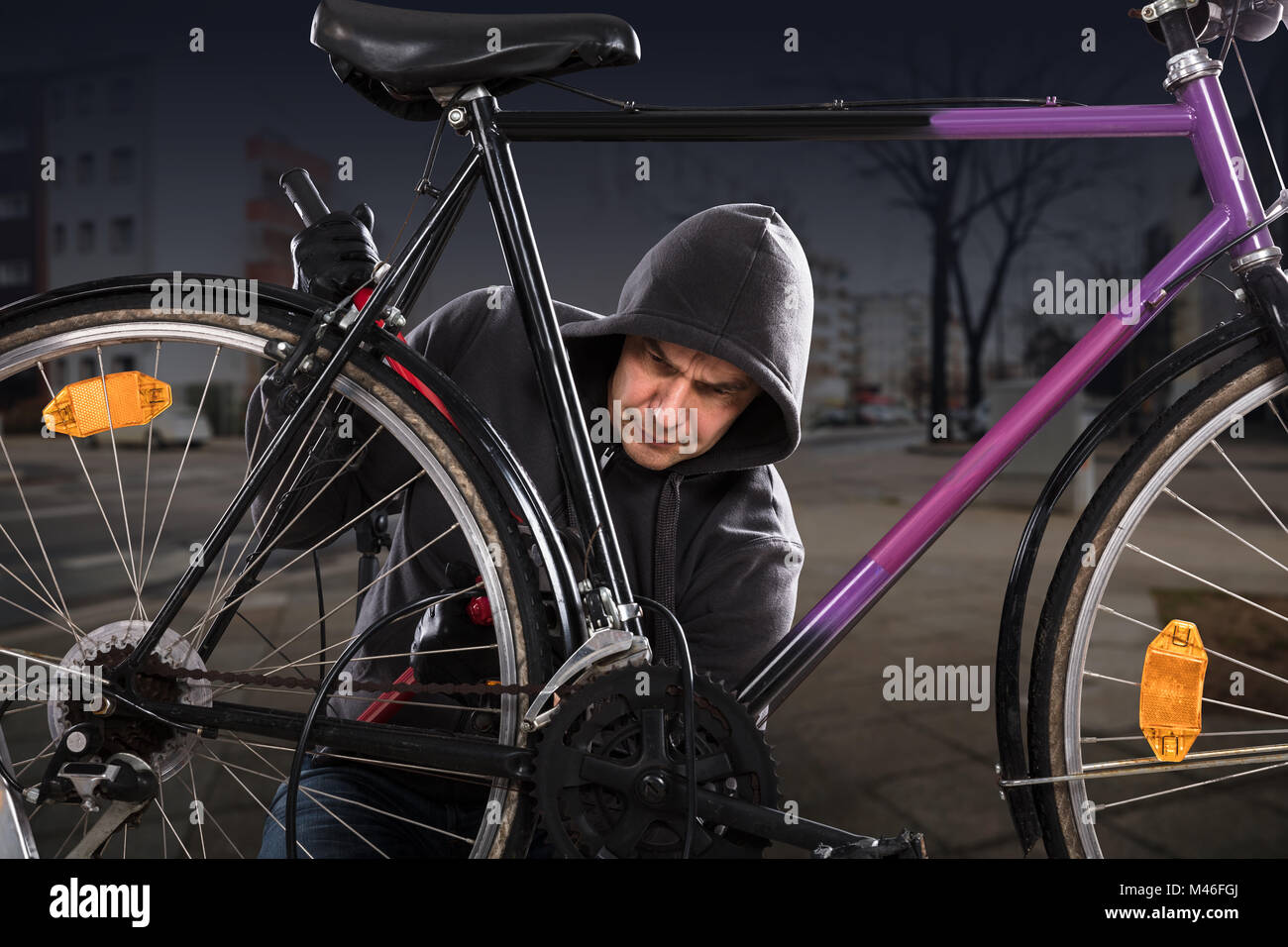 Dieb Mit langen Zangen Das Fahrradschloss zu brechen Stockfoto