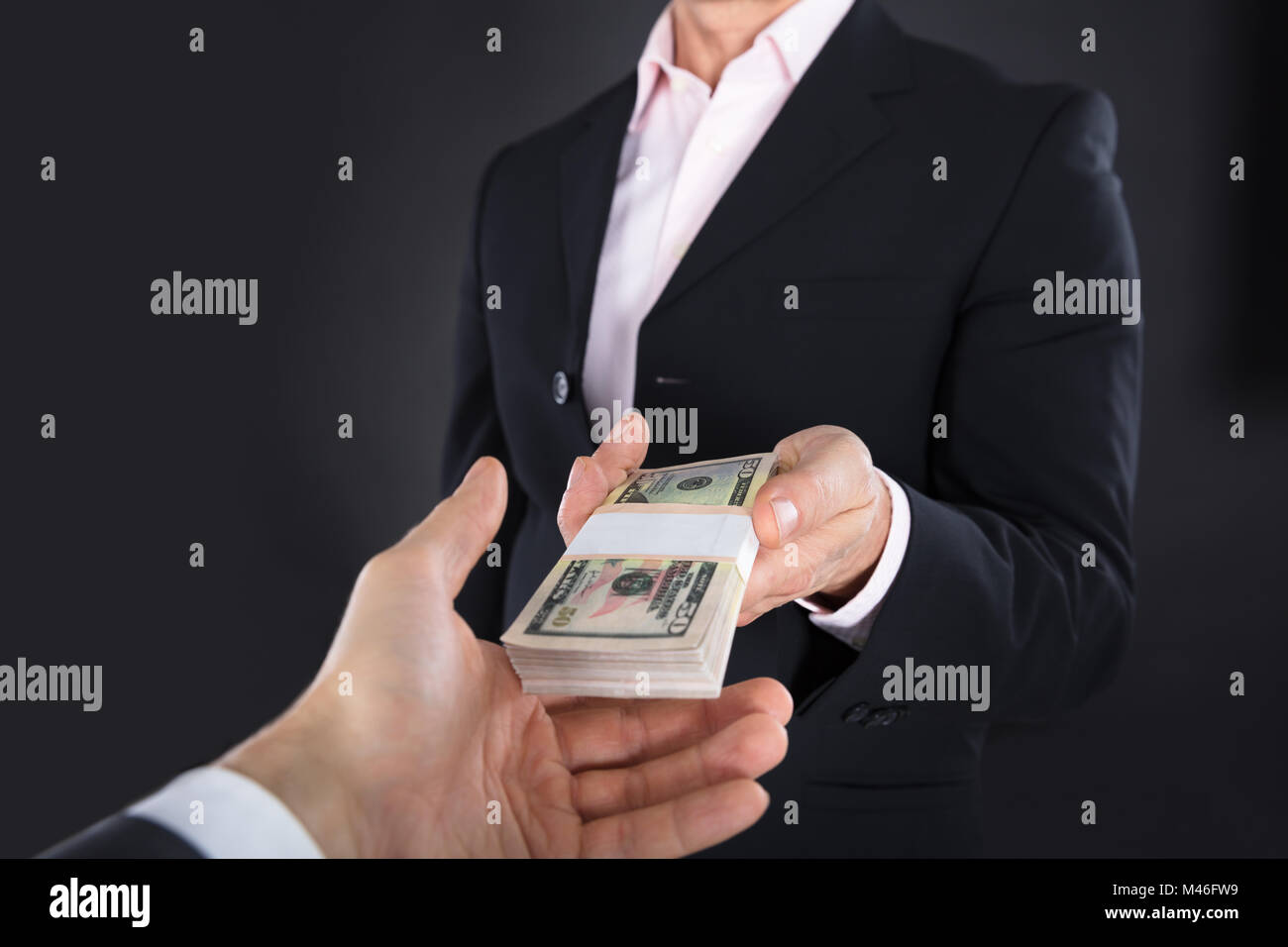 Nahaufnahme eines Geschäftsmannes, die eine Bank Hinweis auf schwarzem Hintergrund Stockfoto